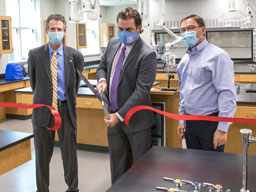 Dr. Hogan, Dr. Argo and Forrest Spicher cutting ribbon in science lab.
