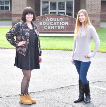 Two adult education students standing in front of the Adult Education Center for a photo.