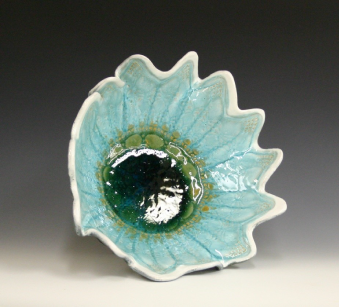 Green fluted bowl with glass in the shap of a flower.