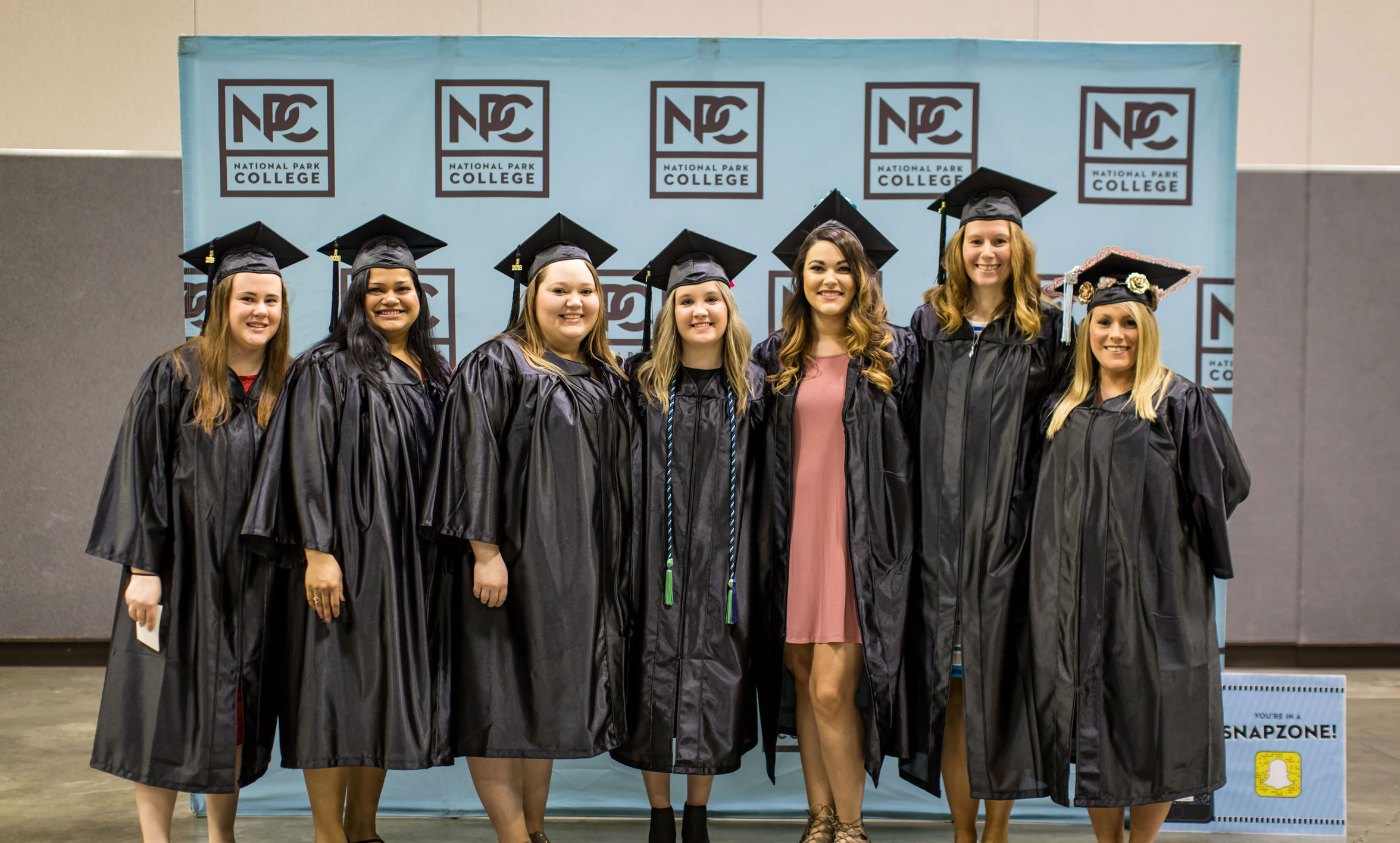 Female graduates smiling with caps and gowns