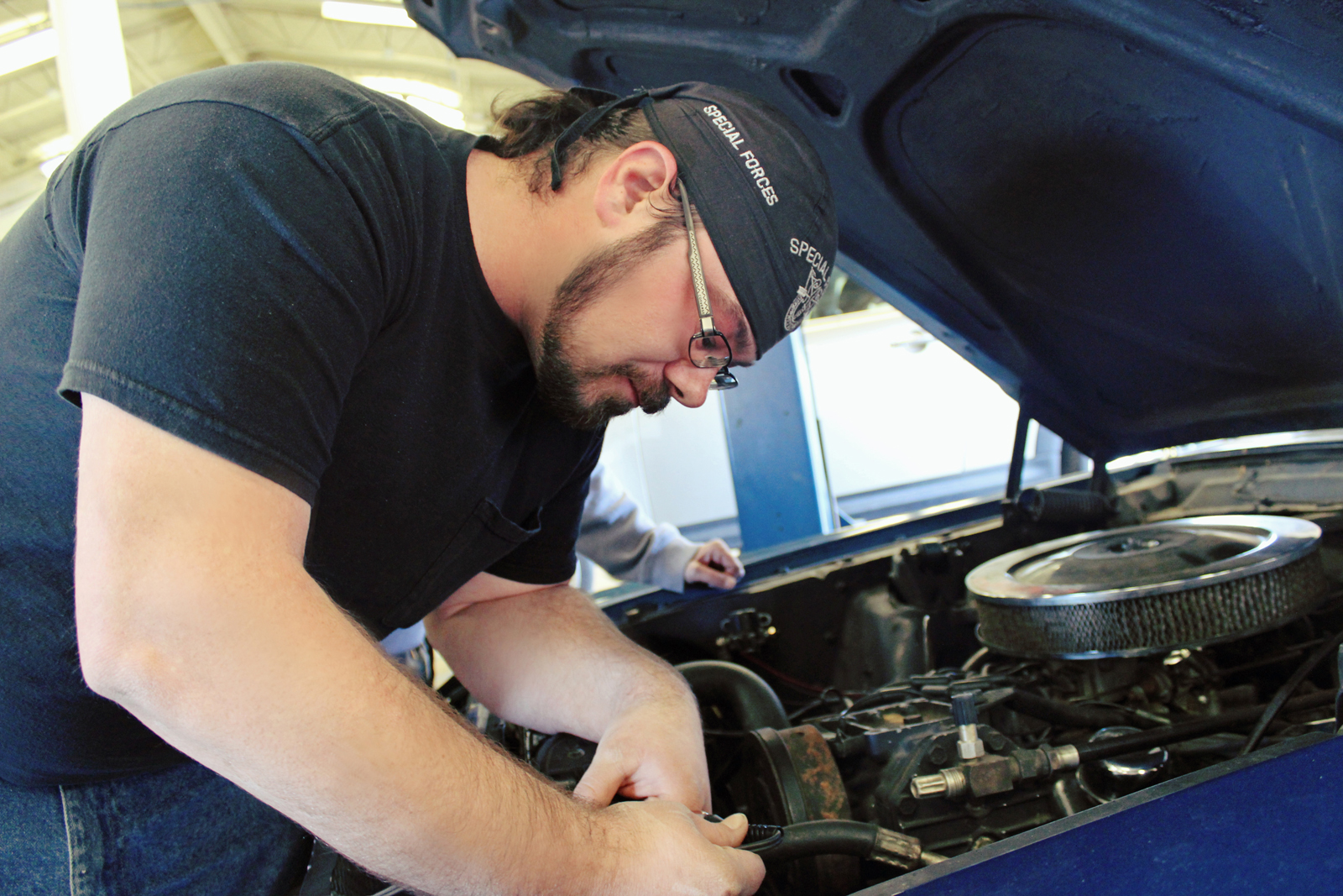 Man working under hood of car