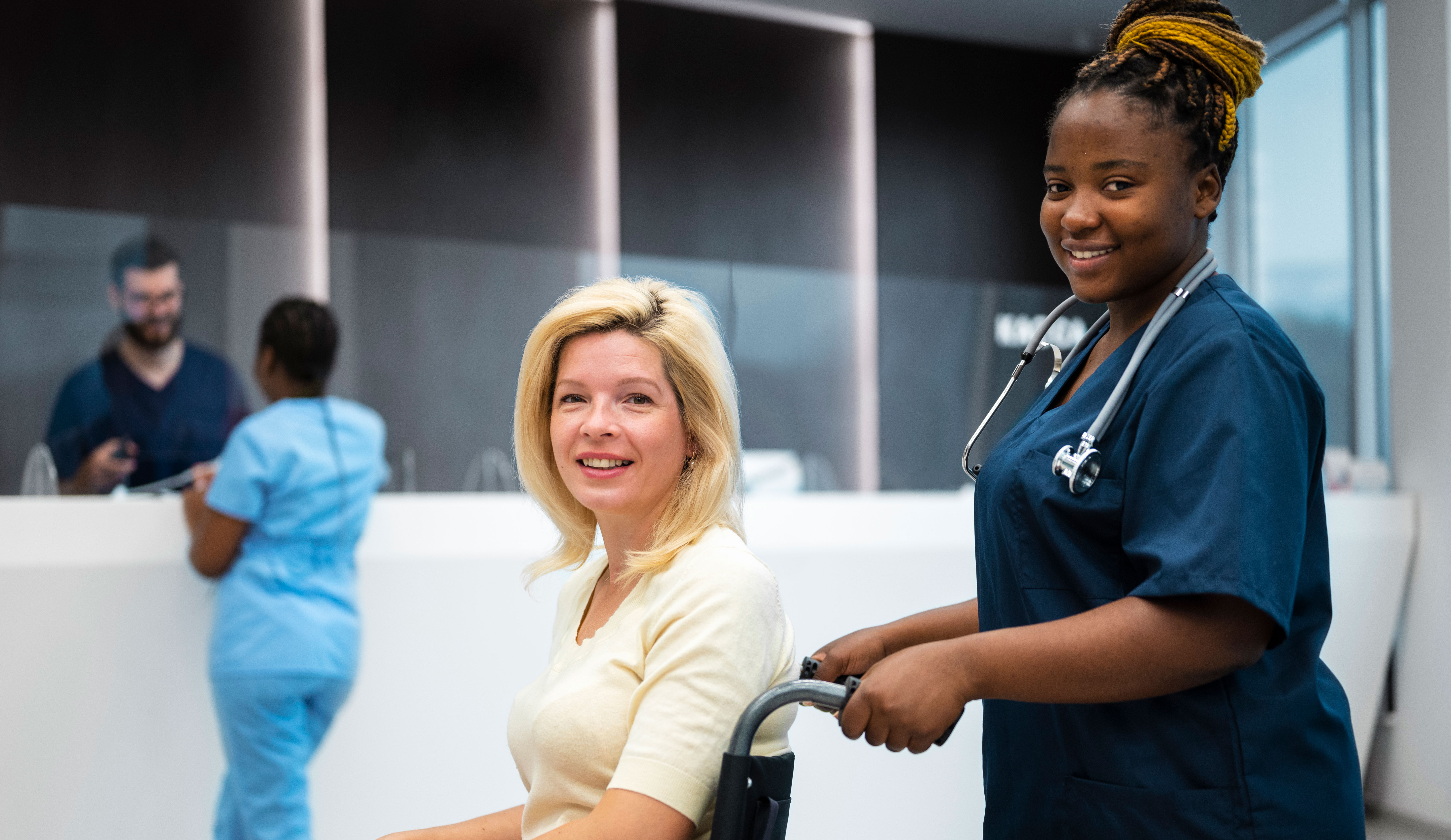 Nurse pushing female patient in wheelchair