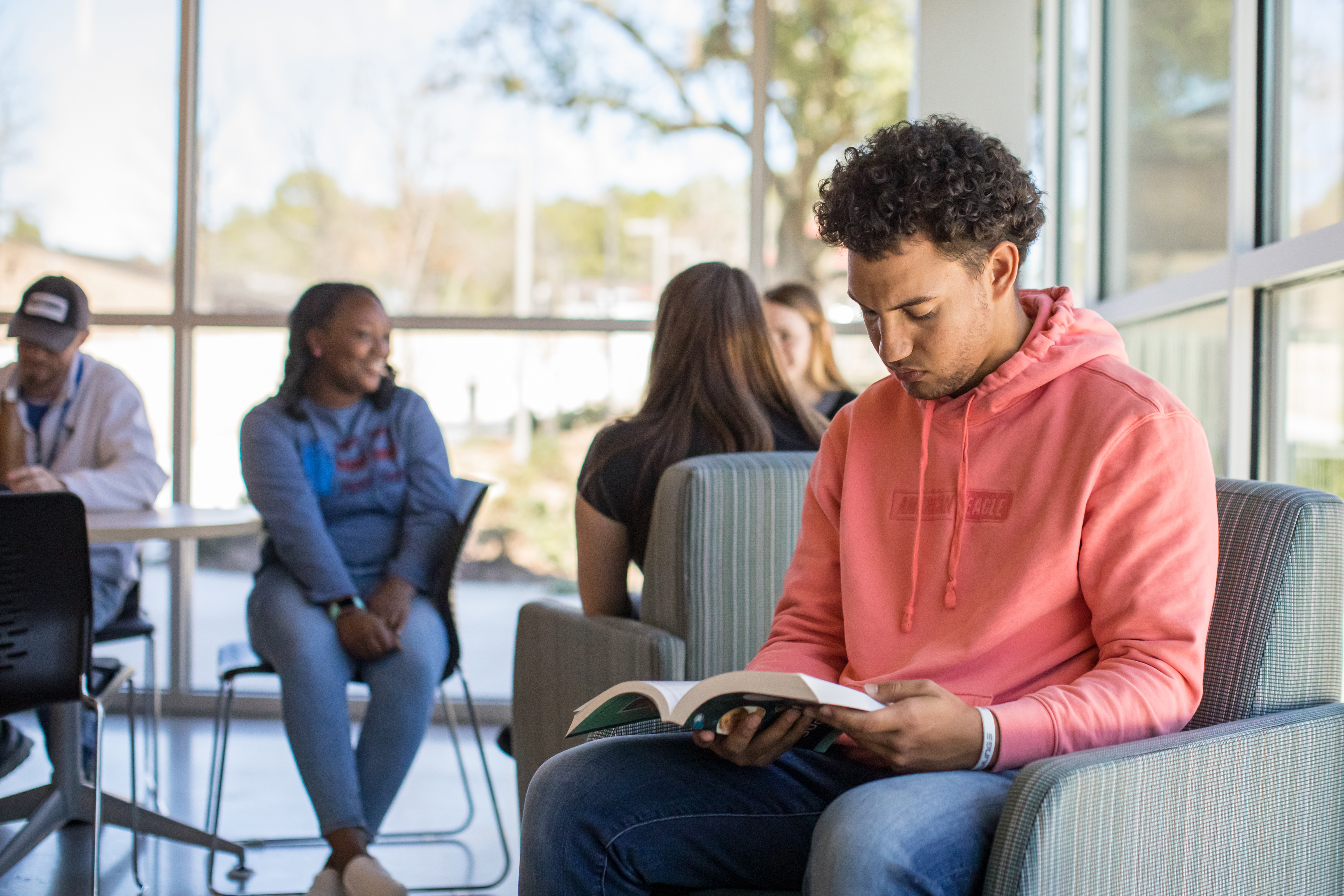 Two students sitting back to back on a bench studying