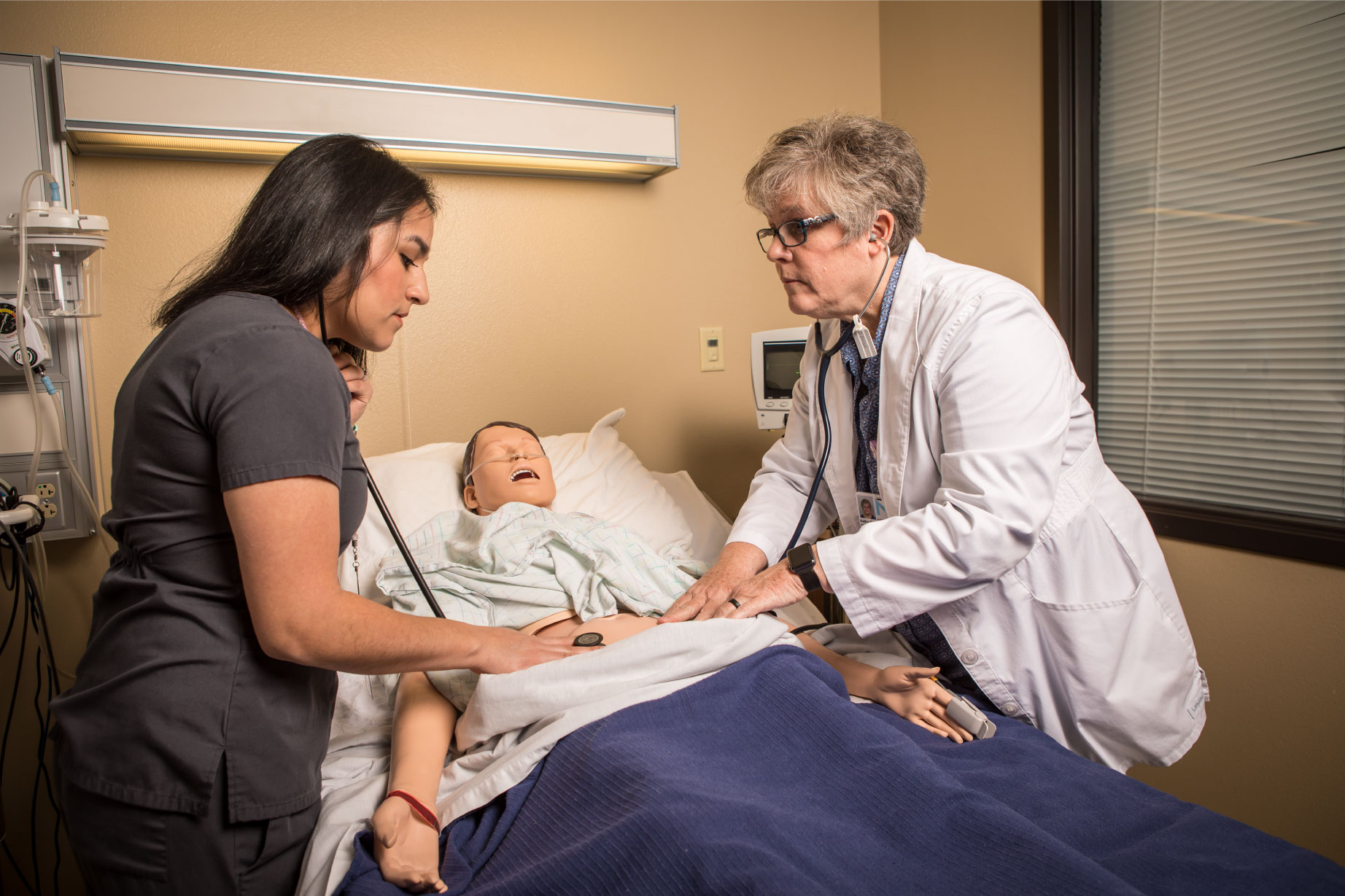 Student and professor checking heart beat in patient stomach