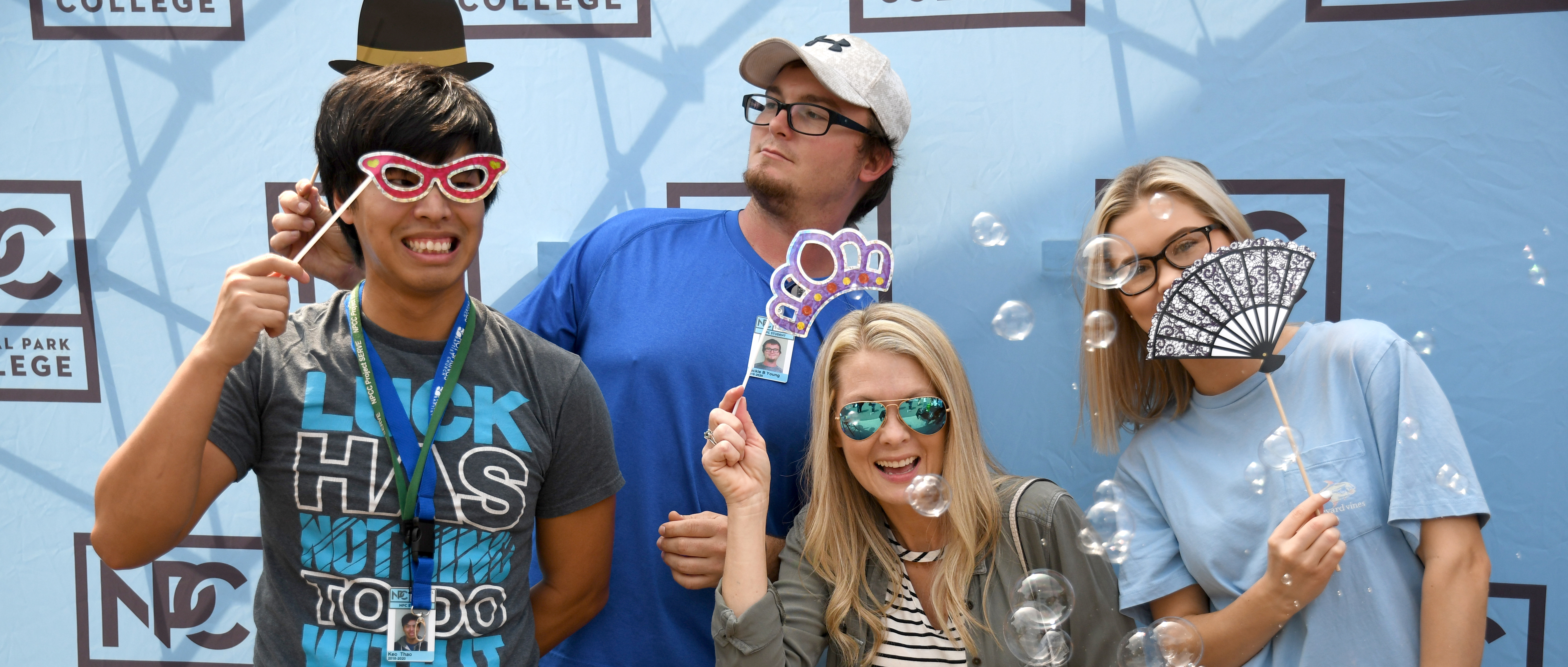 Group of students blowing bubbles with photo booth props