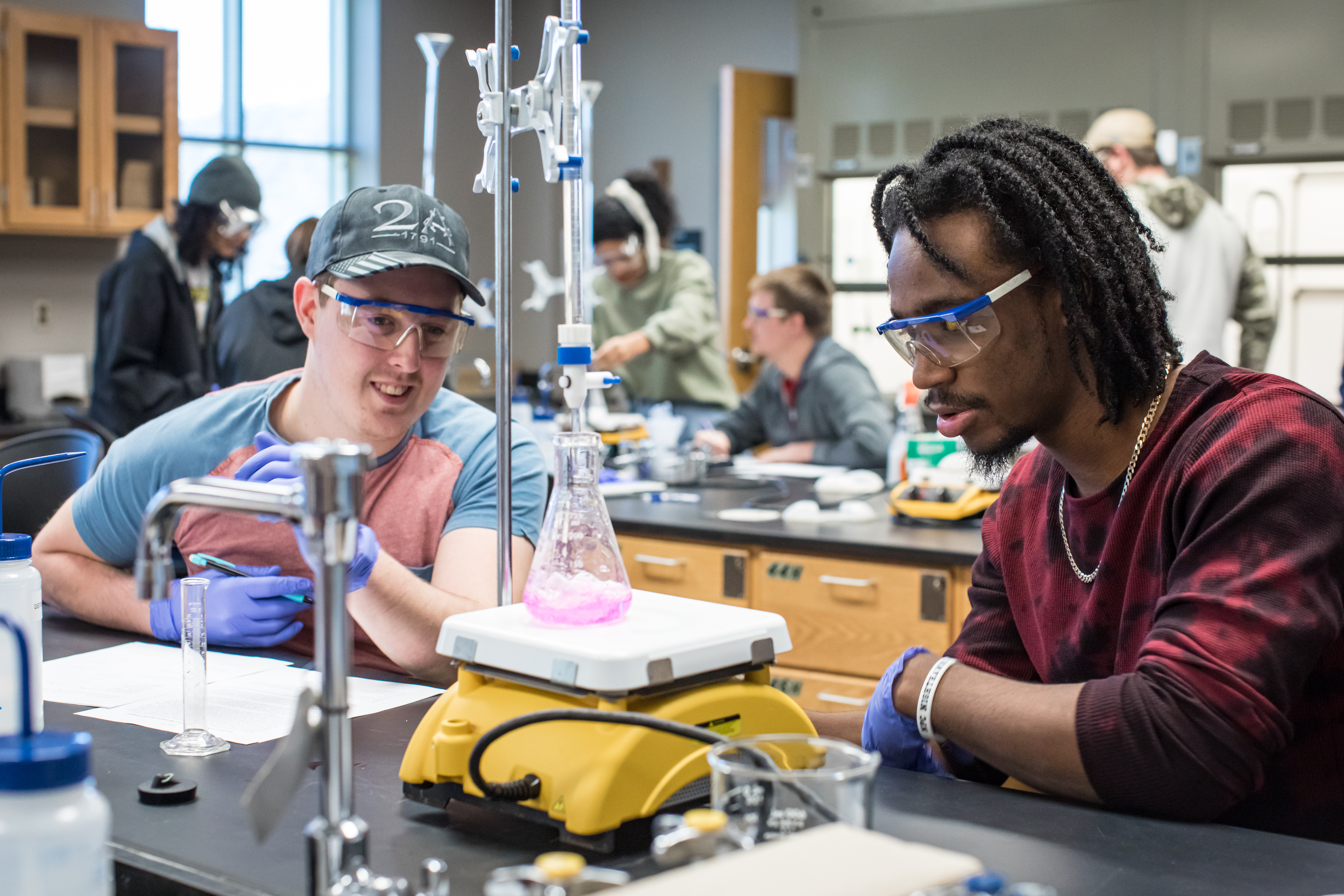 Students working in lab with a beaker