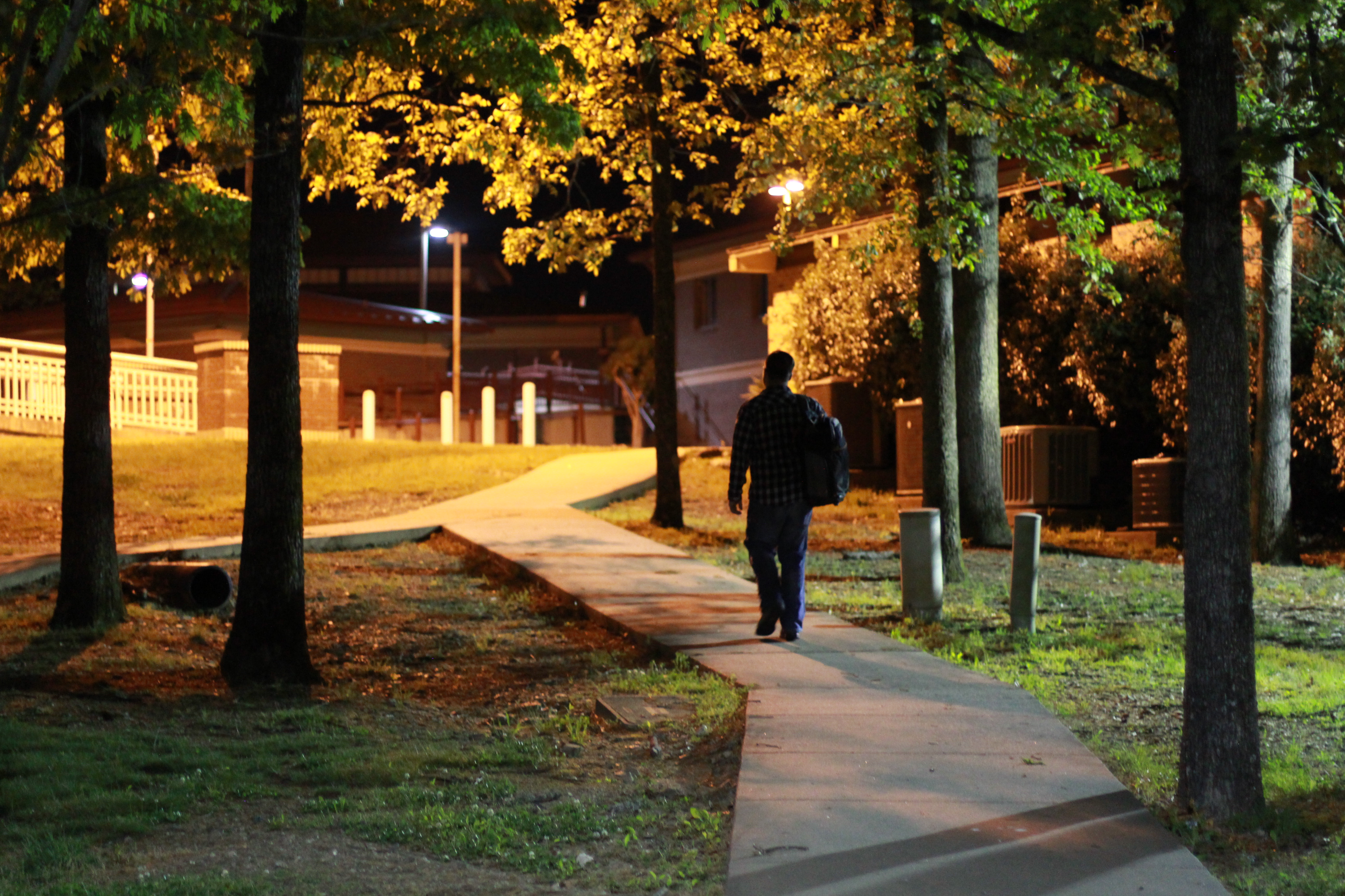 Male student walking on campus at night