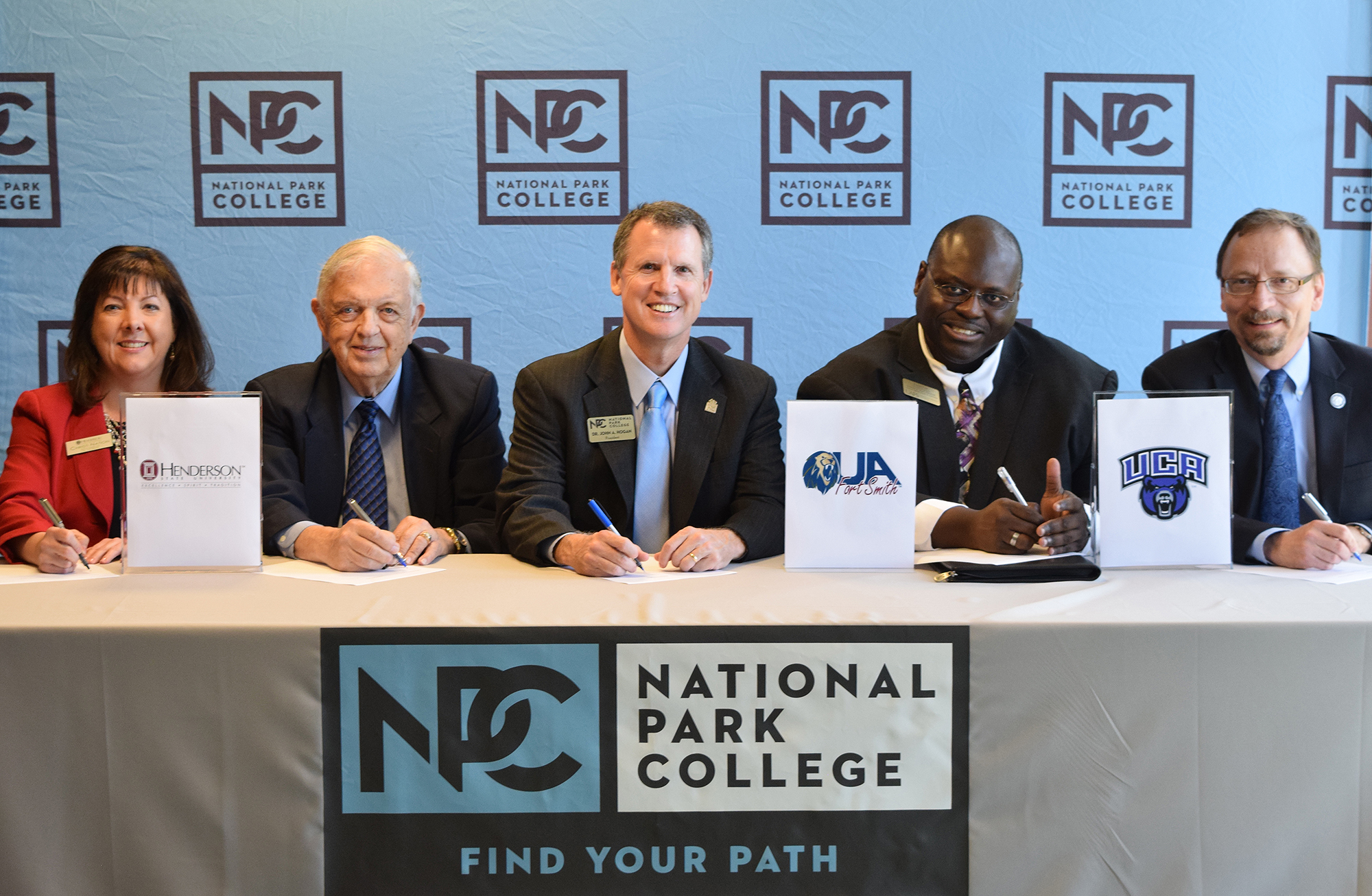 Transfer board signing at table smiling