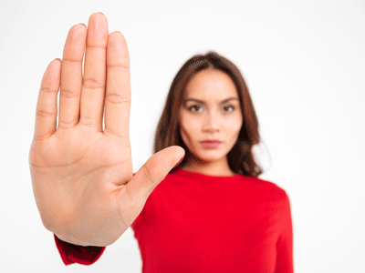 Woman holding hand up and out in a stop fashion.