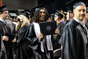 Students in cap and gowns celebrating graduation.