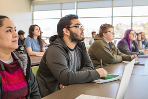 Students sitting at tables in a classroom.