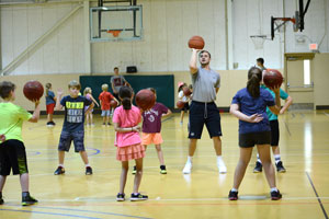 A coach teaching basketball to children