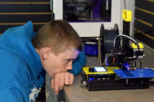 Camper watching a 3D printer print.