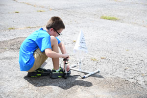 Summer camp child setting his rocket up for launch.