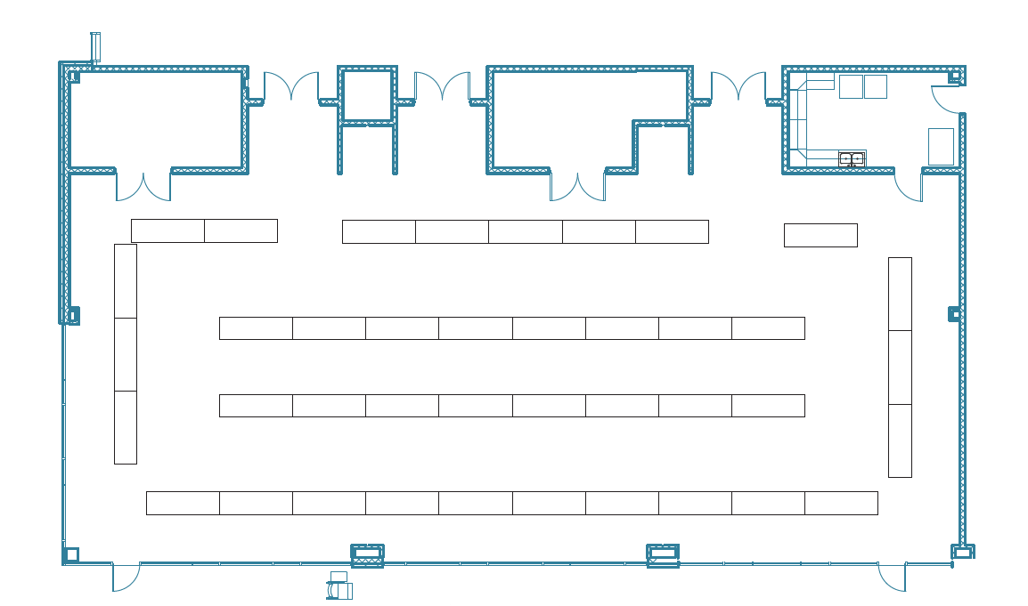 A technical blue-line floor plan of the Student Commons conference space configured for a booth setup. The diagram shows a large rectangular room with three rows of vendor tables in the center and additional tables lining the perimeter. The top of the plan features specialized areas including storage, a hospitality suite with a kitchenette, and multiple entry and exit points.