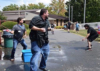 Students and faculty participate in water balloon fight after debate.