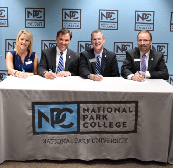 Three board members from Henderson State University and University of Central Arkansas with Dr. John Hogan signing for the approval of 22 new transfer degrees.
