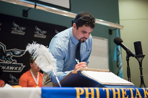 Colby Morgan signing his name as a new member to PTK.
