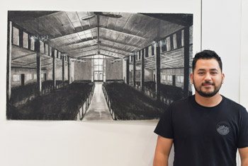 Julio Rodriguez with his work of charcoal on paper
