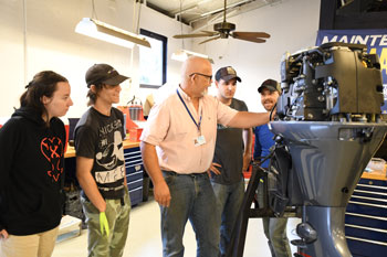 Marine Technology students and instructor standing beside a Yamaha 115 VMax SHO motor.