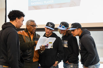 Dennis Biddle reading out of his book to NPC baseball players