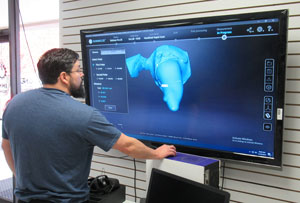 NPC student Mark McCorkle checking the impression of Scarbroughs arm on a big screen monitor