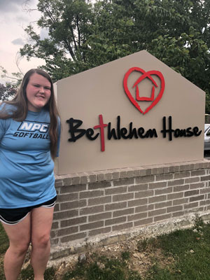 Sarah Todd, NPC student, standing next to the Bethlehem House sign.