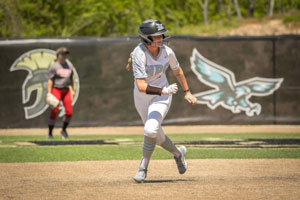 Softball player Hannah Harvey rounding the bases headed to third. 