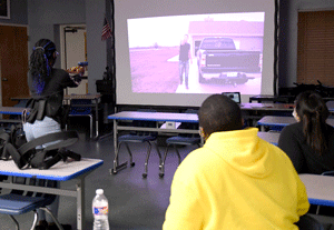 Students used a LaserShot simulator to respond in police training scenarios in classroom.