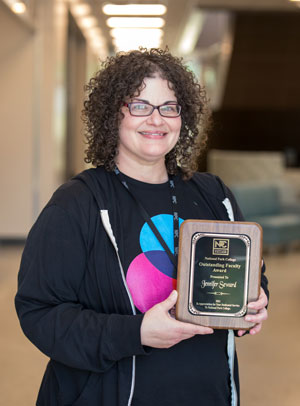 Jennifer Seward holding her Outstanding Faculty plaque.