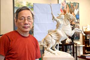 Longhua Xu standing next to his sculptor The Visitor which depicts a Native American woman holding a staff while sitting on a horse. 