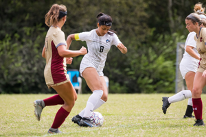 Yassenia Vargas defending the soccer ball against opponets.