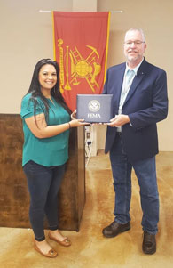 Jessie Ellis and Chris Foreman holding a FEMA certificate leather case. 