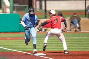 Demias Jimerson running to base and as he is about to step on it the other team player is reaching out with his glove.
