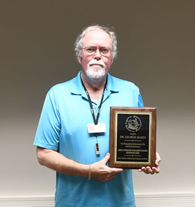 Dr. George Maxey holding plaque.
