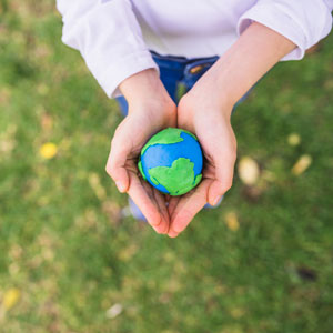 Person holding clay Earth in hands.