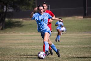 Nighthawk Emily Gorrelle keeps soccer  ball away from opponent.