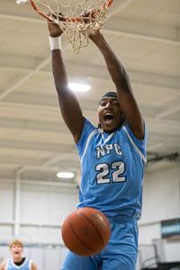Nichus Jackson hanging from basketball hoop.