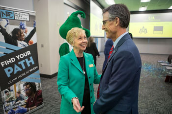 President for NPC, Dr. John Hogan, and UAM Chancellor Dr. Peggy Doss talking and smiling.
