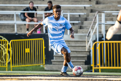 NPC soccer play Ali Muganga dribbles the ball down the field.