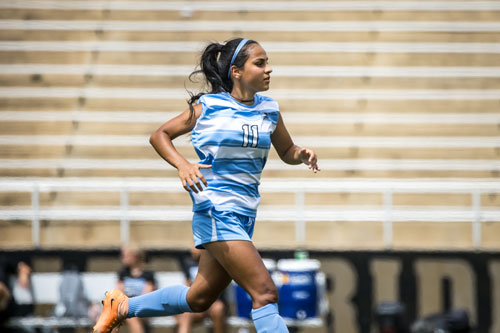 Soccer player Alondra Limon running down field. 