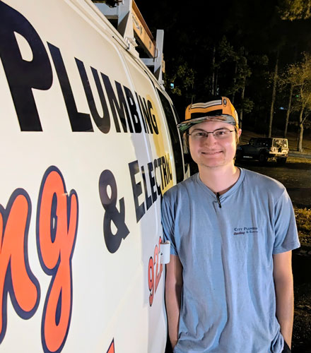 Colten Brady standing next to a work van. 