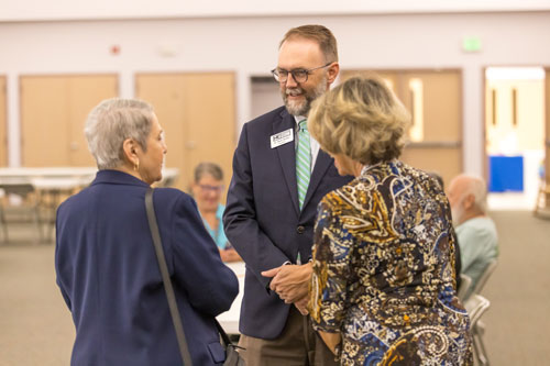 Wade Derdent talking to two members of the community.