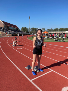Kaylie Goad giving thumbs up as she stands on the running track.