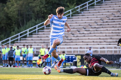 Linberth Soriano keeps soccer ball away from opponent.