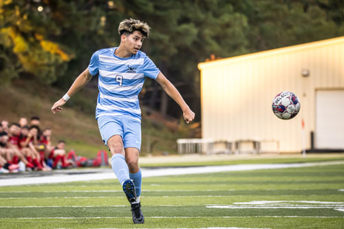 NPC men's soccer player is preparing to kick the ball.