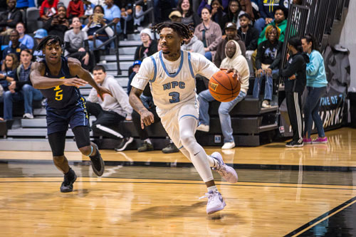 Mondo Watkins dribbling the basketball.