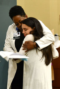 Two people hugging, one is a nurse the other is a nursing student.