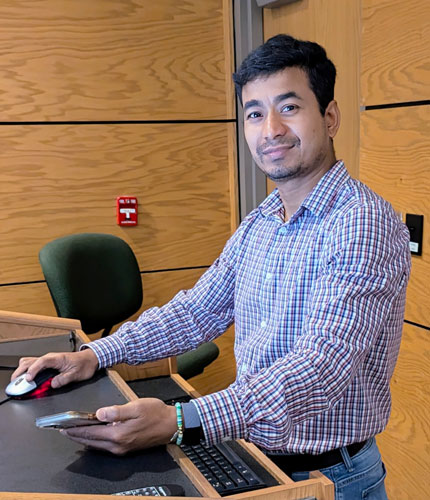 Assistant Professor of Chemistry, Uttar Shrestha standing at a podium.