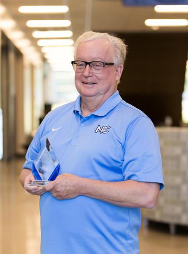 Dr. Chuck Burke holding his outstanding faculty award.